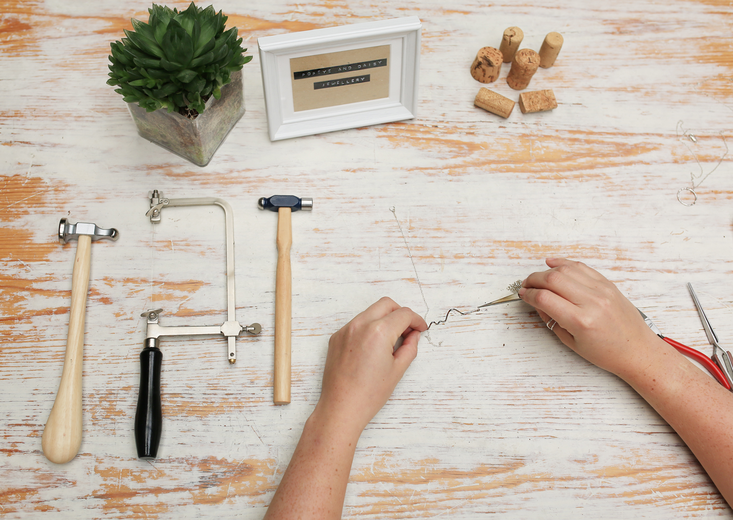 A flat lay of a jewelers hands working on silver