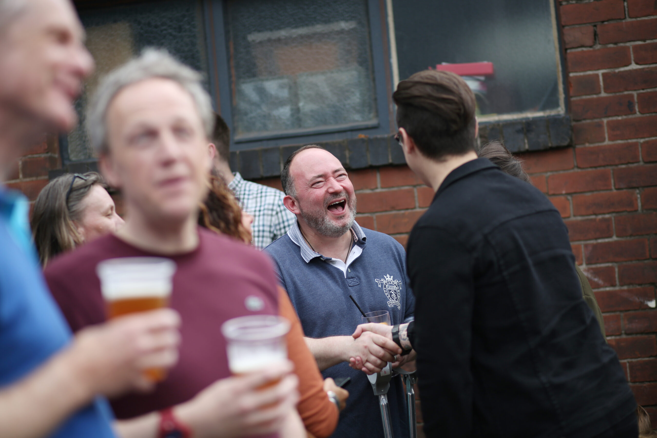 A candid photograph of people laughing at a bar